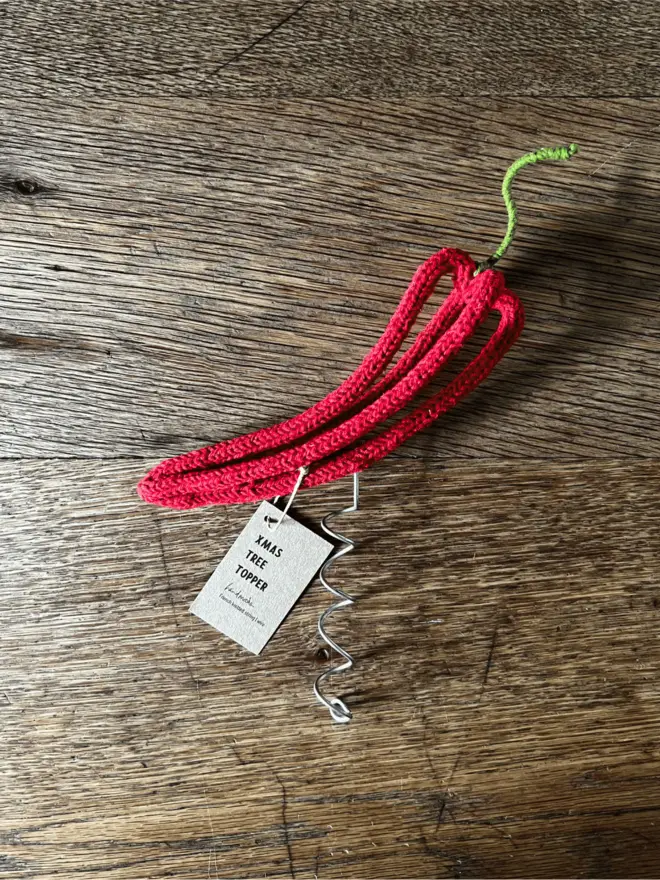 Wire and string Chilli Xmas tree topper with label resting on an oak table