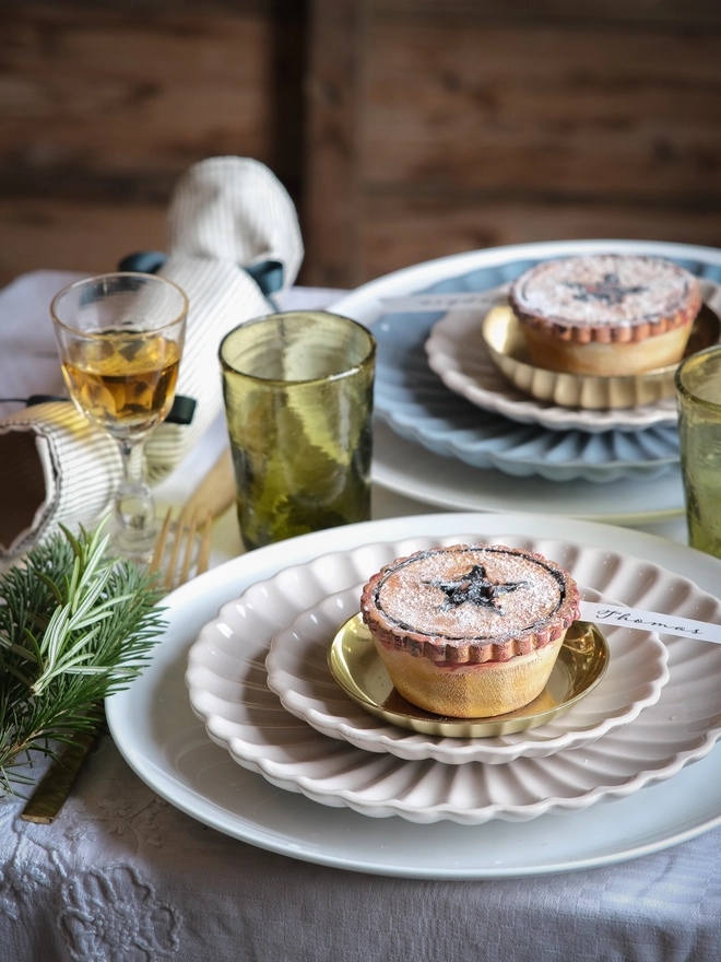 A festive handpainted wooden mince pie place setting with handwriten note to welcome your guests at the Christmas table
