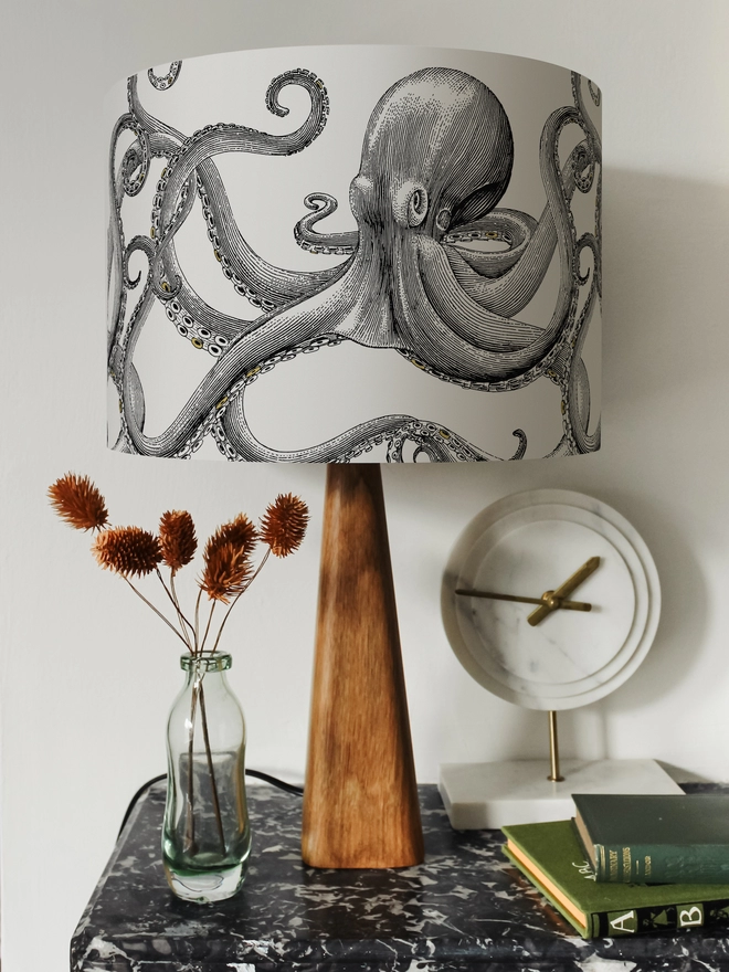 Drum Lampshade featuring Octopus on a wooden base on a shelf with books and ornaments