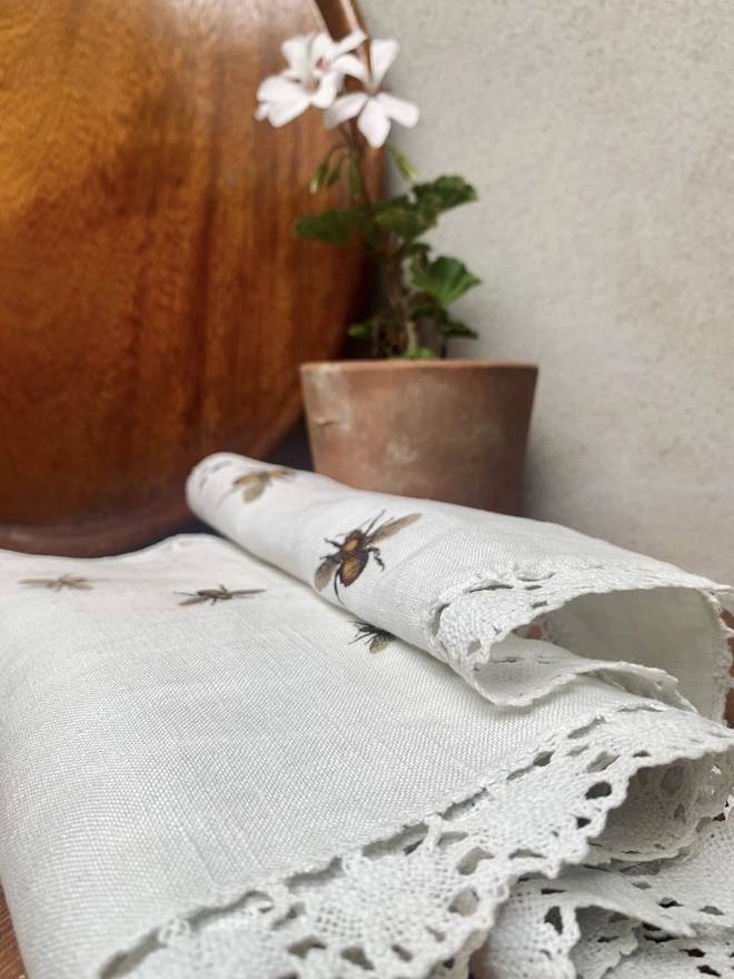 An upcycled vintage linen and lace table runner with printed bees