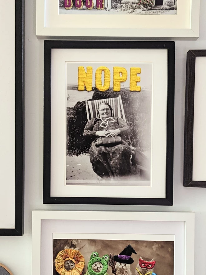  B & W photo print of woman with yellow embroidered ‘nope’ framed on wall
