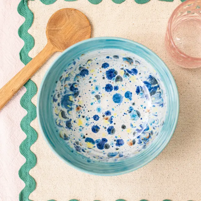 Shoreline Ramen Bowl, a colourful ramen bowl placed on a set table accompanied by utensils and glasses. 