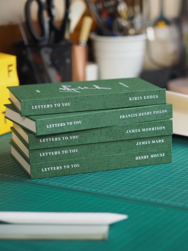 a stack of letters to your journals made up on a workbench