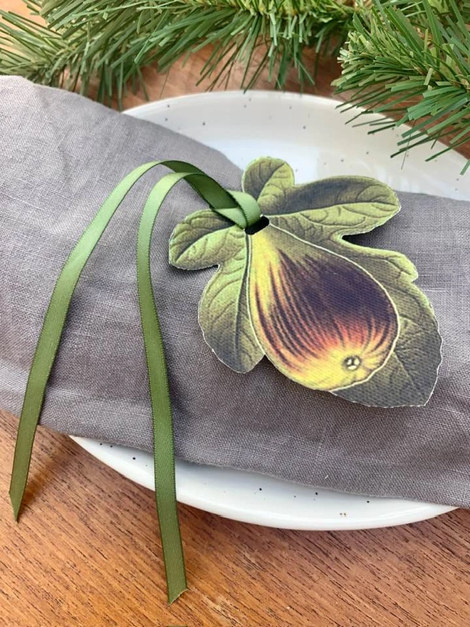 A hand tied napkin holder place setting with festive greenery