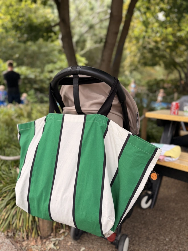 Green stripe bag over handles of pram