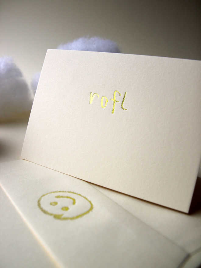 sandy coloured card with rofl short for 'roll on floor laughing' hand foiled in kids hand writing