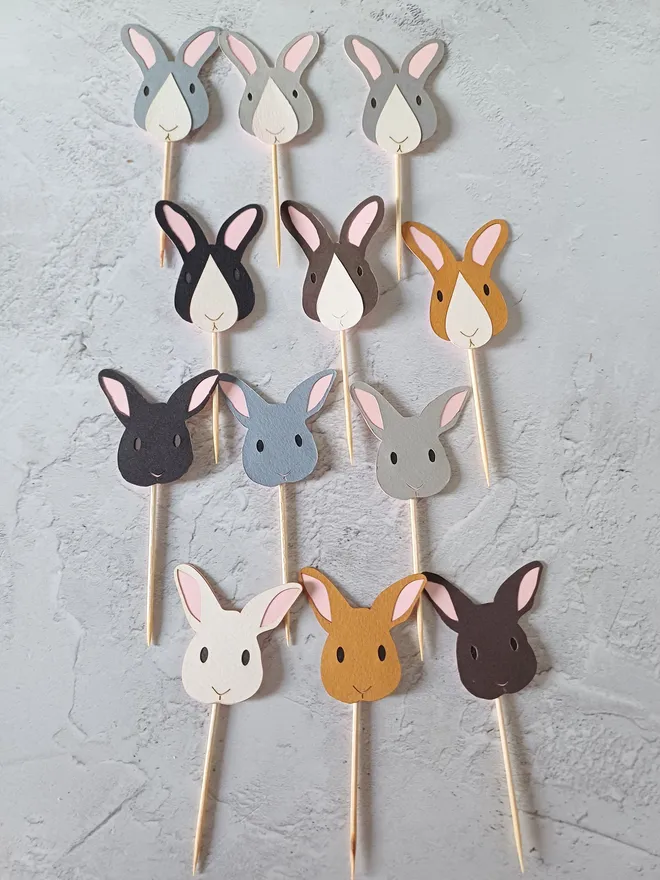 Full Set of Easter Bunny Cupcake Toppers. Colour variations laid out left to right,  top to bottom: Dark grey, Pale grey, mid grey all with white nose patch, blakc, dark brown, toffee brown all with white nose patch. Dark brown, Dark grey, pale grey, white, toffee brown, dark brown all solid colour faces.  