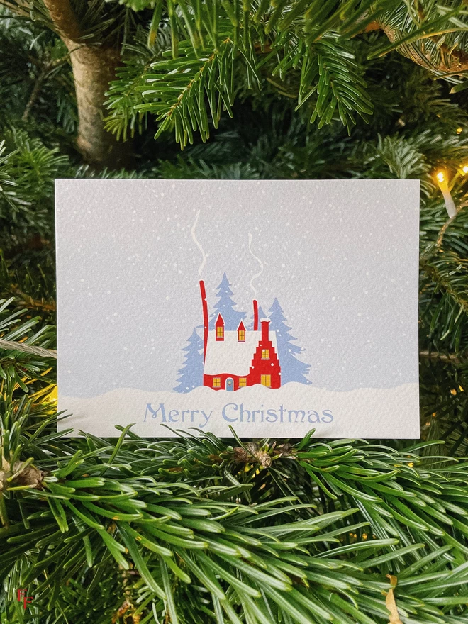 Christmas cabin card sitting in a christmas tree