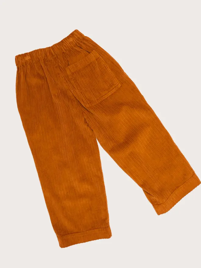 Back flat lay of Studio Koter Ever trousers in umber corduroy, showing the rear patch pocket.