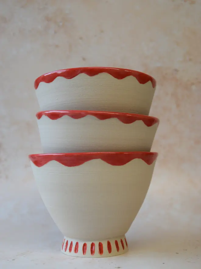 Handmade ceramic bowls — stacked set with red scalloped rim and textured glaze