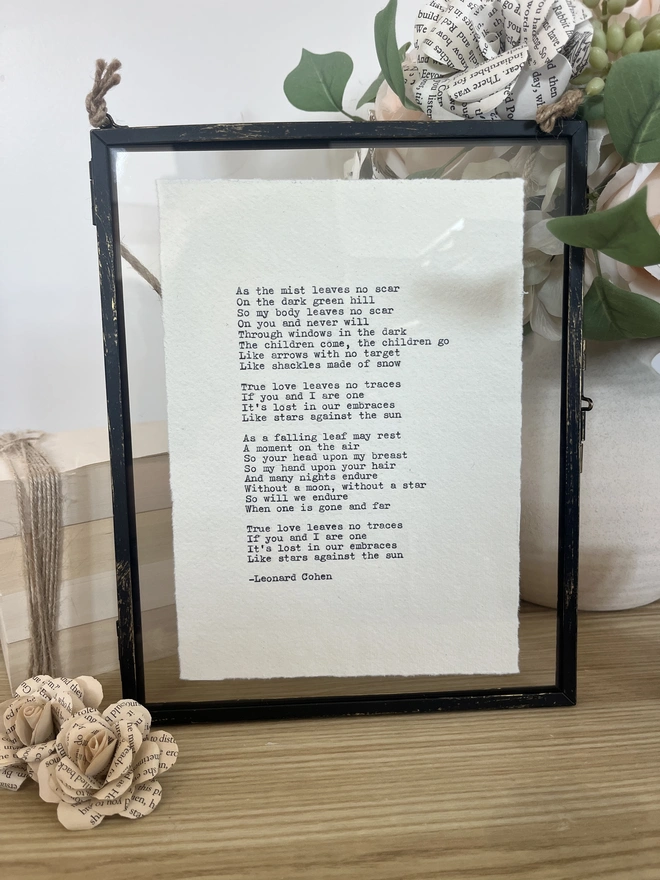 Framed typewriter print hand typed with an antique typewriter onto cotton rag handmade deckled paper. It is displayed in a black hanging rustic frame with gold brush detailing.
