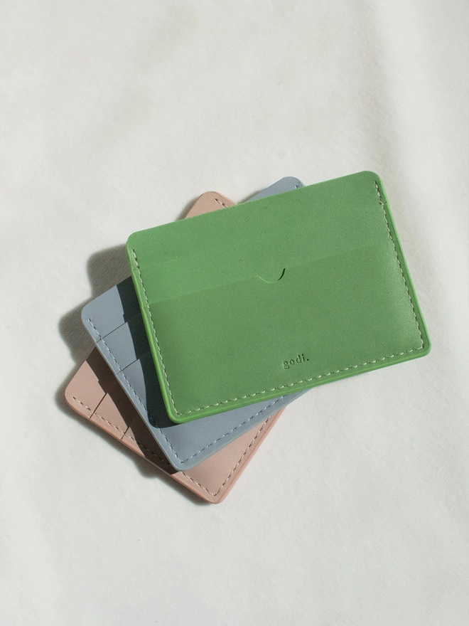 Image of the card cases with the sea green laying on top of the ice blue and nude pink colours