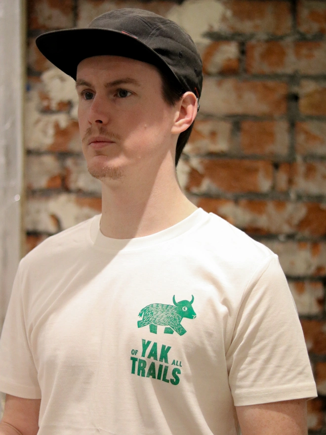 Man wearing a t-shirt and hat, a Yak linocut image printed on the white tshirt