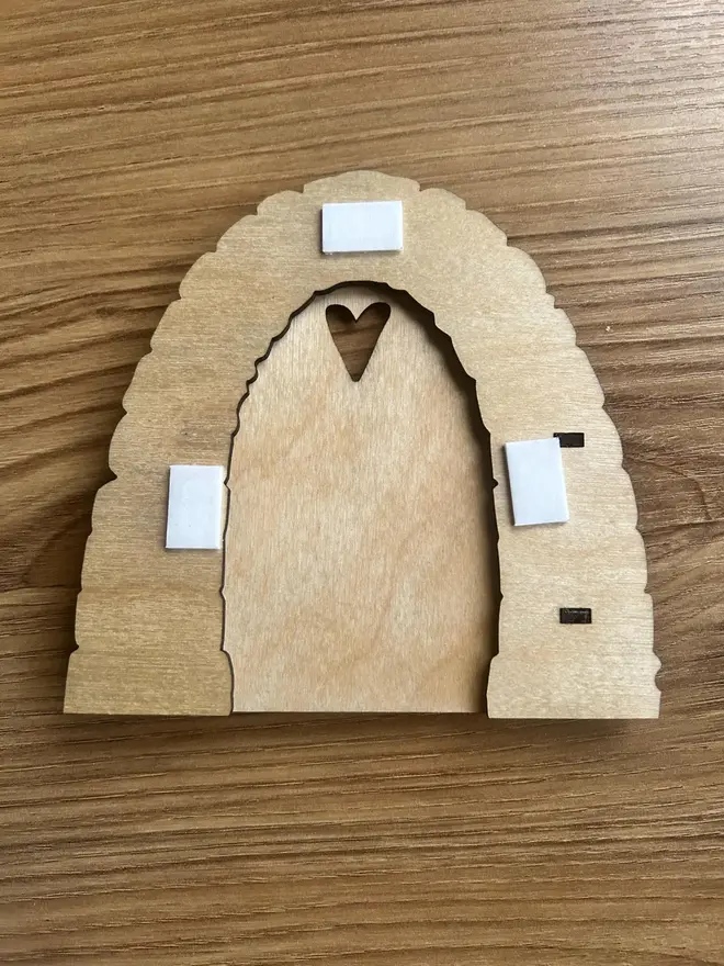 Rear of wooden fairy door with adhesive pads.