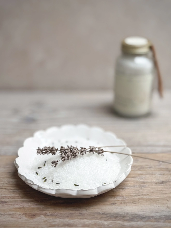 lavender bath salts in a dish with the jar in the background