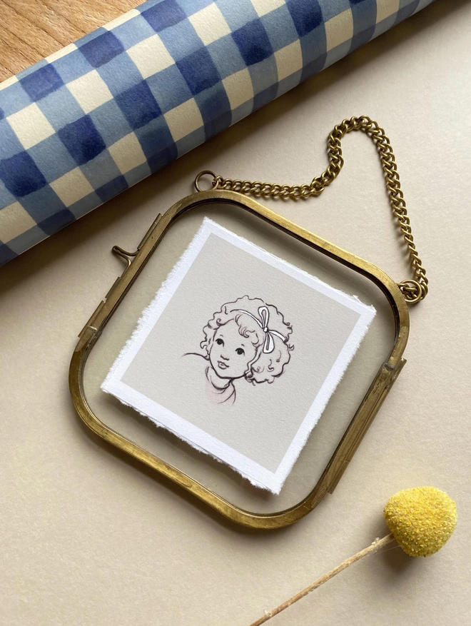 a miniature portrait of a little girl framed in a glass frame