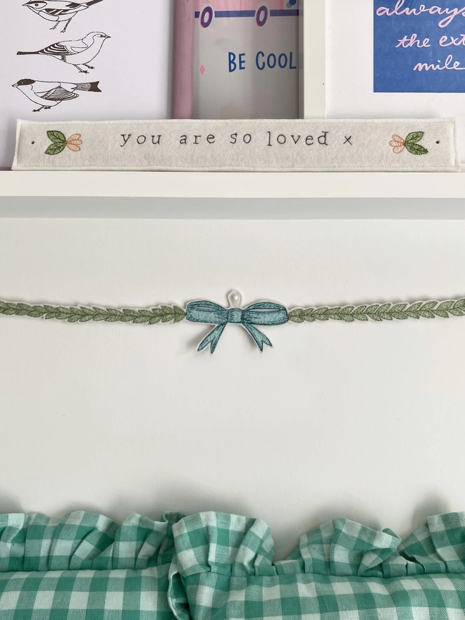 You are so loved embroidered felt sign on a shelf with bow decoration