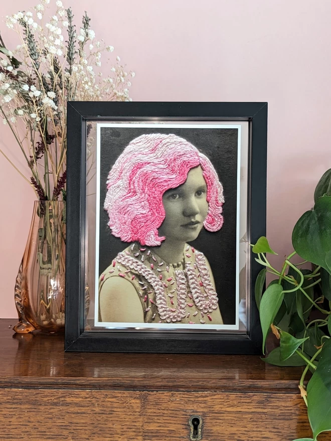Print of B&W girl, with embroidered pink hair and dress in frame