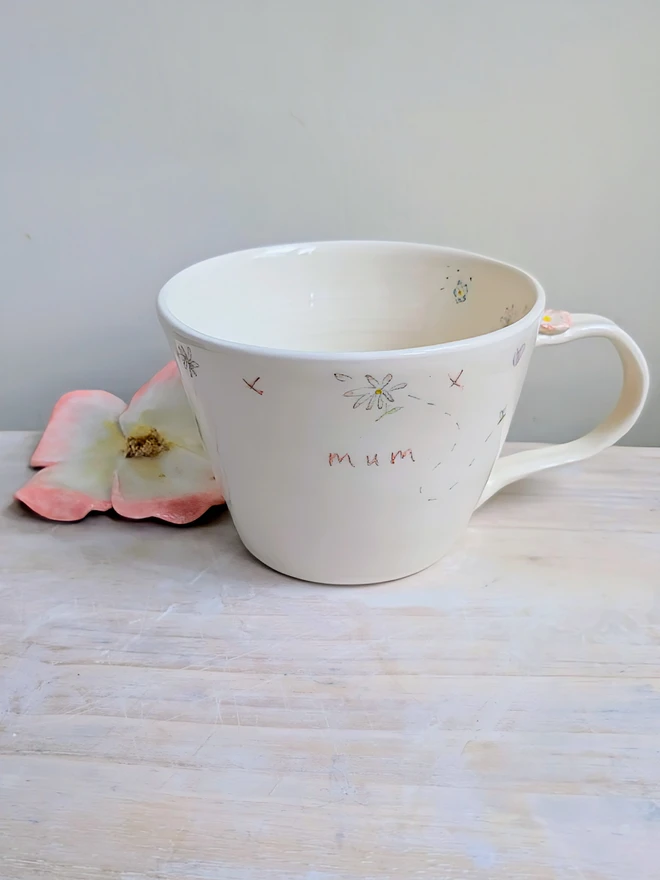handmade ceramic cup for mum with flowers, daisy hearts and tiny honey bee in white earthenware with pink highlights
