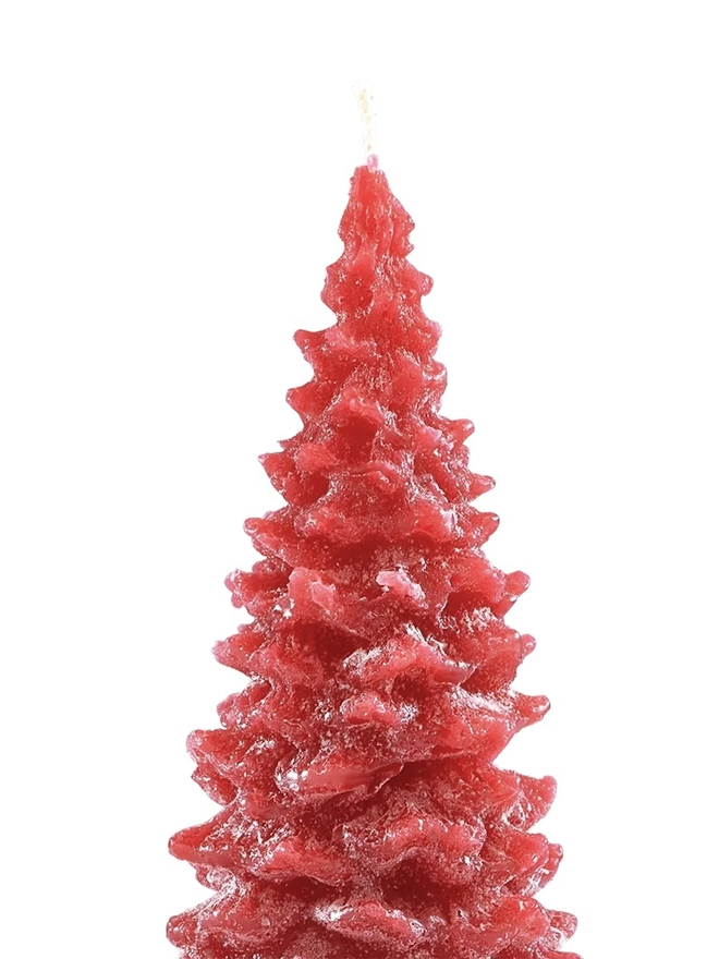 Green Or Red Christmas Tree Candle (Set Of 3). a close-up shot shows the top section of a red christmas tree shaped candle on a plain white background. the textured, layered pine branch design is visible in detail, with the wick extending from the tip of the tree. the rich red wax has a slightly mottled finish, adding to the realistic, hand-poured look of the candle.