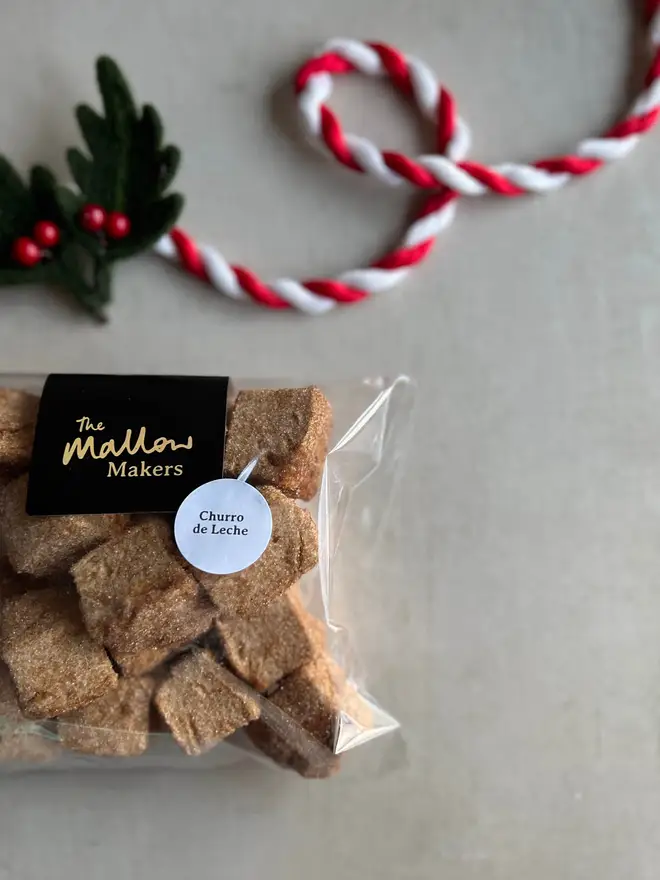 The-Mallow_makers-Looking-down-on-packet-of-churru-de-leche-marshmallow-bites-coated-in-cinnamon-sugar-with-christmas-ribbon