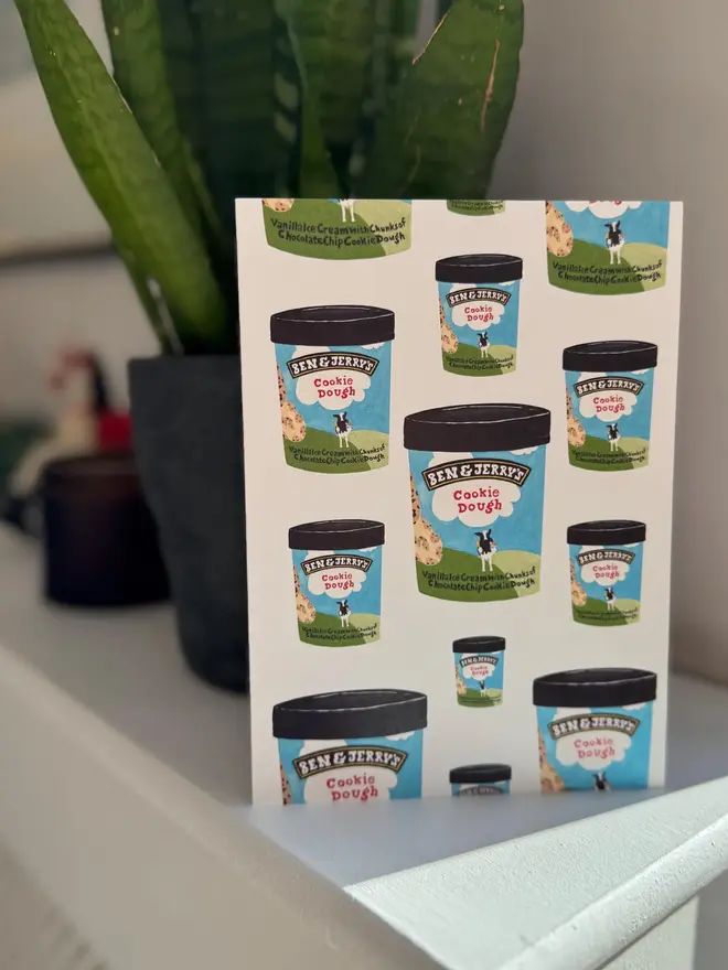 cookie dough ice cream illustrated card. card photographed on mantelpiece with houseplant in background.