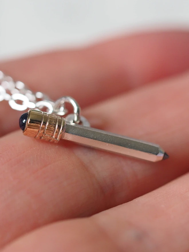 Sapphire dinky pencil charm on a hand