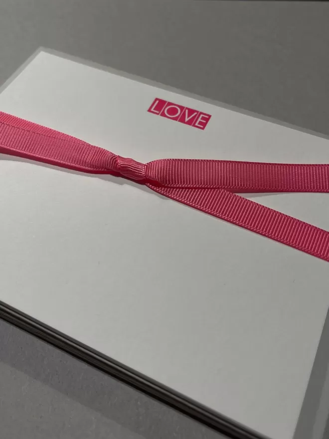 South London Letterpress with a Love neon pink notecard seen with pink ribbons.