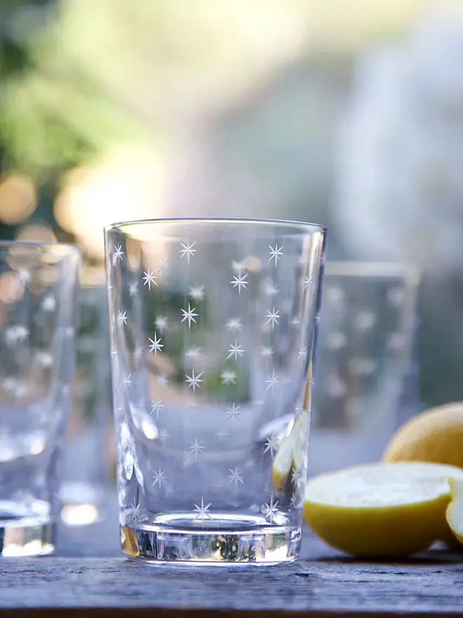 engraved stars crystal tumblers (set of 6). a tumbler glass patterned with small stars.