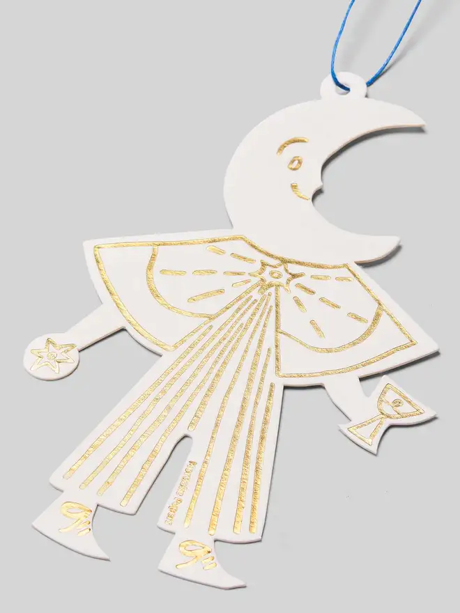 Decorative cutout ornament of a moon folk figure on a gray background