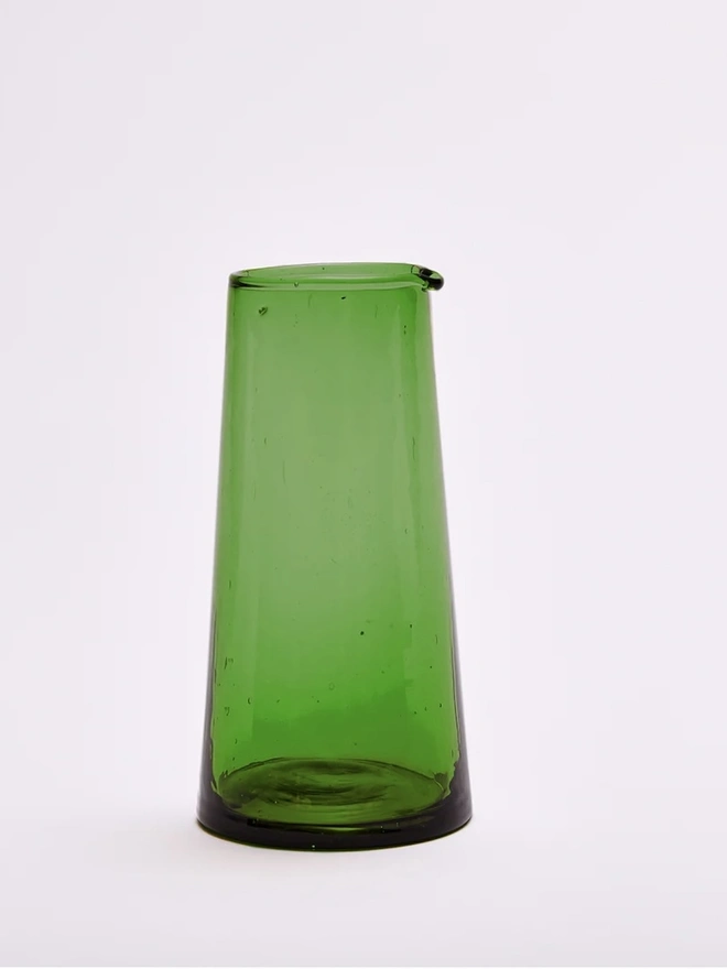 Tall Jug, a tall green glass jug sitting on a plain counter top against a white backdrop. 
