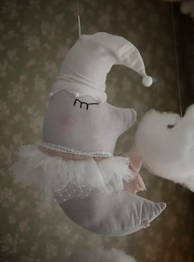 Sleepy Moon Nursery Pillow Hanging Decoration, a hanging pillow decoration suspended in a bedroom. 