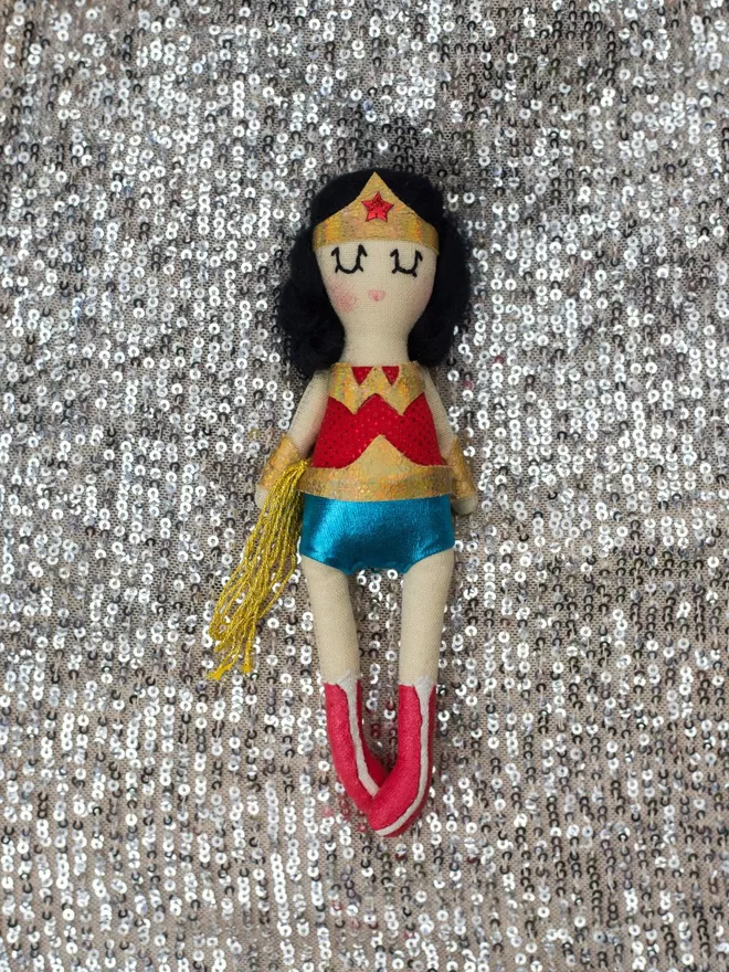 Wonder Woman doll by Jennifer Jackson seen on a sequin fabric.