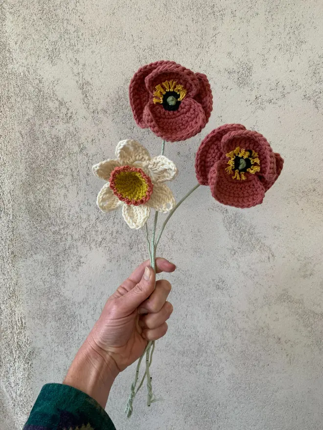 Hand holding crocheted flowers