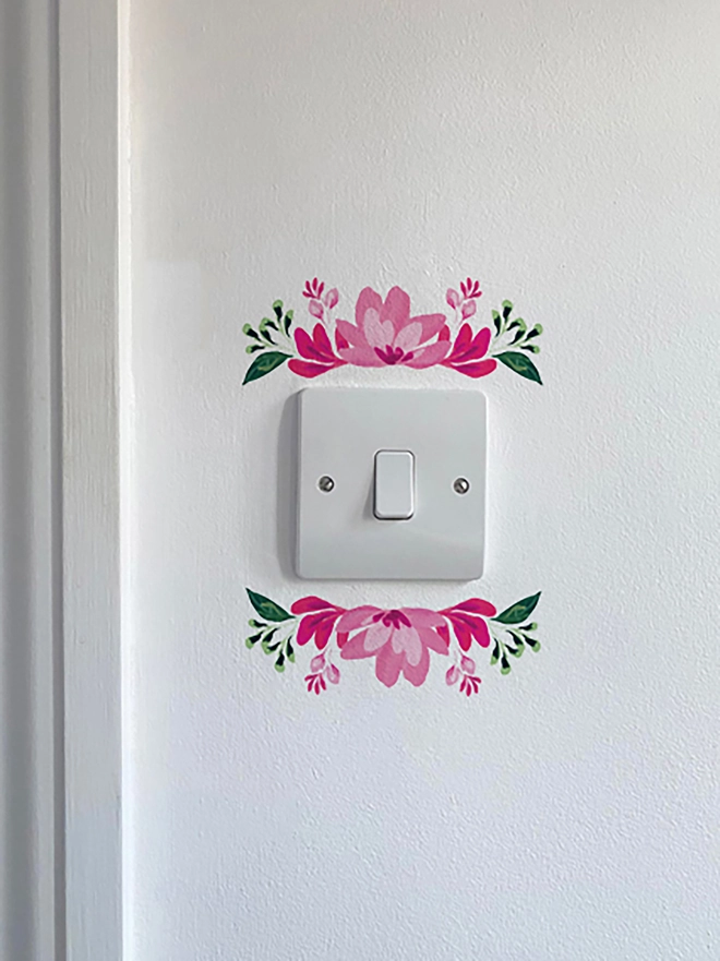 Light switch floral wall sticker, flower detail above and below light switch, handpaitnted floral design in shades of pink