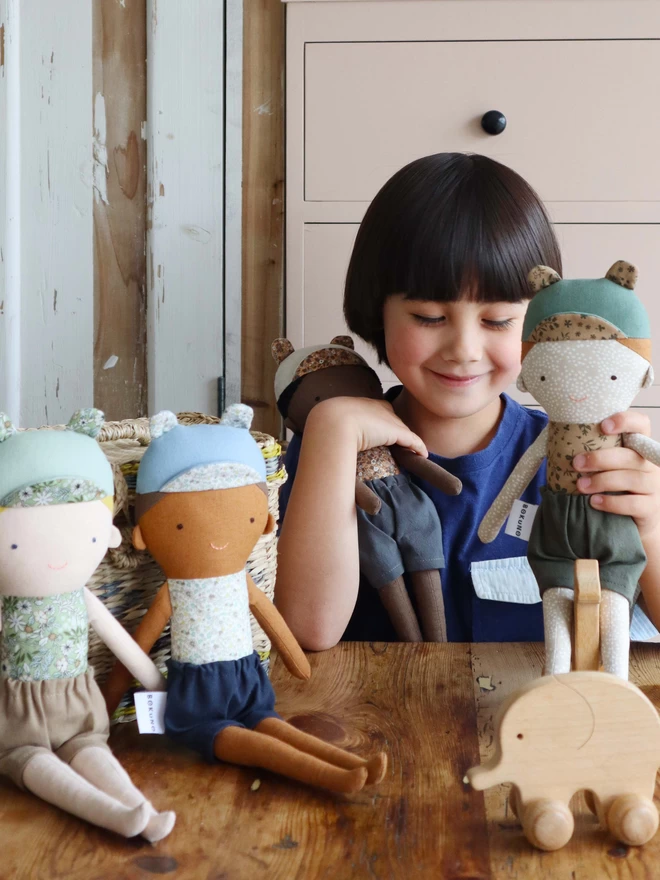 boy playing with fabric boy dolls in different ethnicities