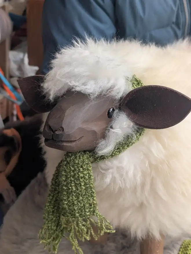 Sheep footstool with a green scarf.