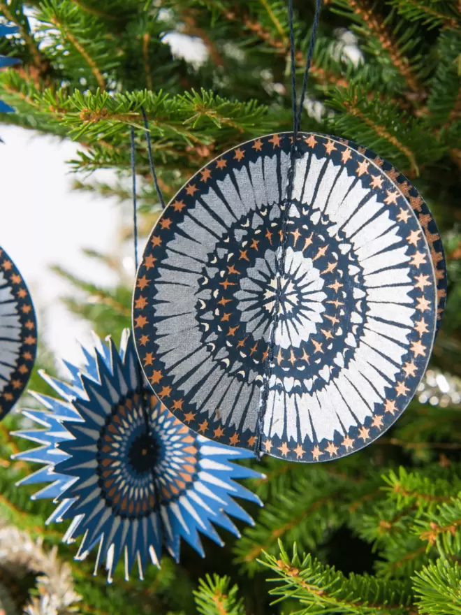 Blue and silver star paper hanging on tree