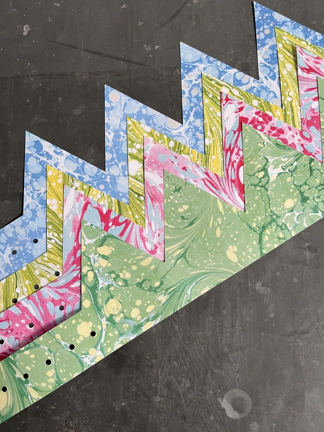 Hand-cut adjustable paper crowns printed with original marbled designs