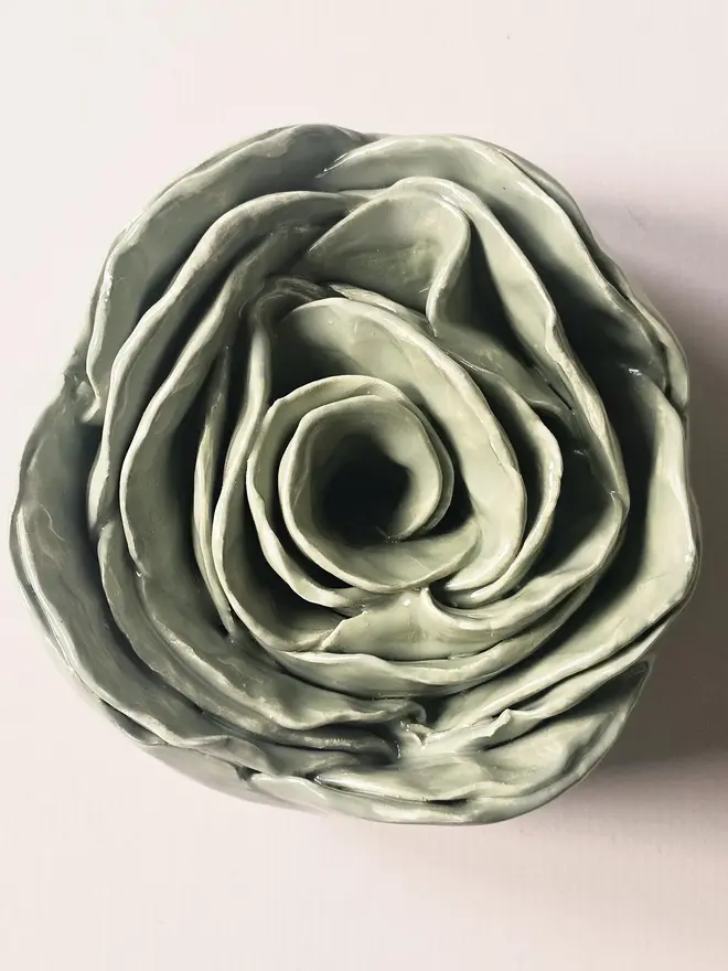 Handmade ceramic rose sculpture with a green glossy glaze, crafted in 3D and designed to hang on a wall