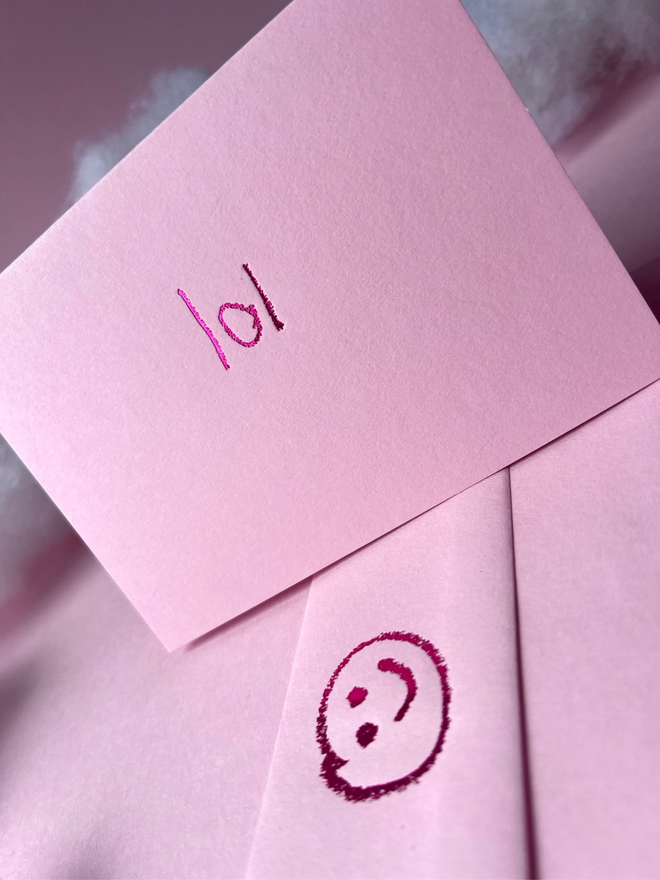 pastel pink coloured card with lol short for 'laugh out loud' or 'lots of love' hand foiled in kids hand writing