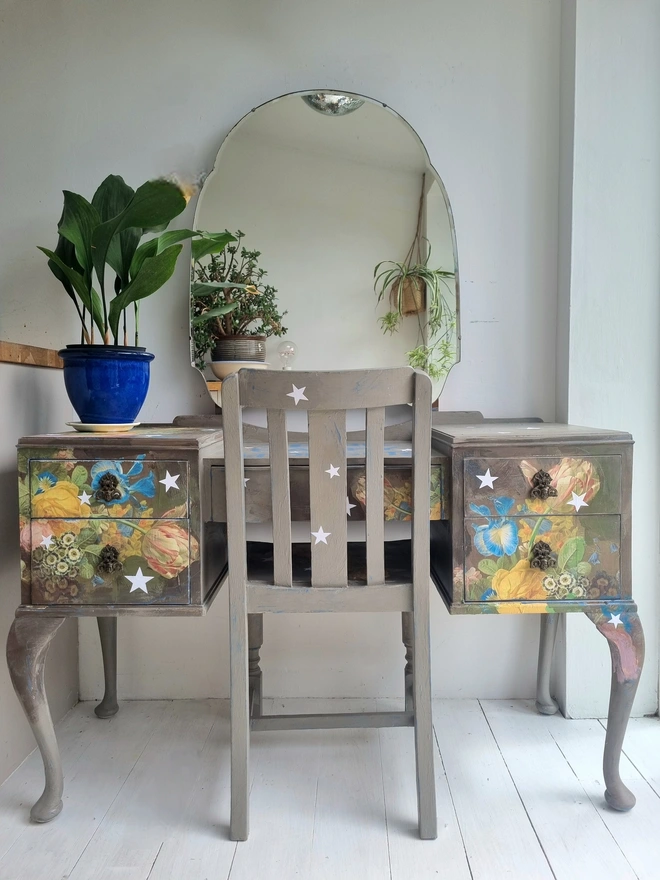 Vintage painted dressing table and chair. Painted in coffee grey and decorated using layered antique florals with yellow and blue accents and finished with hand-cut white paper stars. Text reads in blue 'think happy thoughts'. Heavily distressed finish.