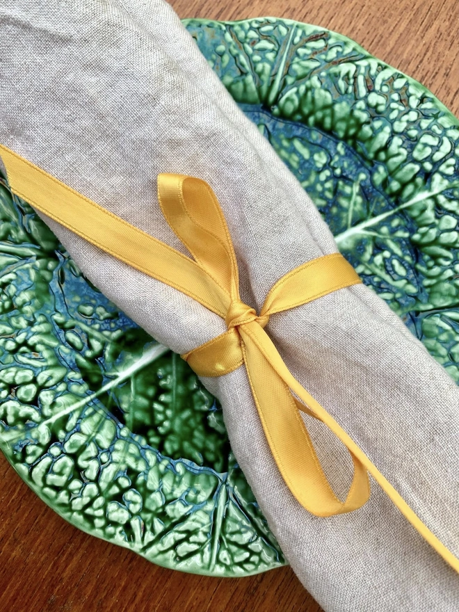 a gold ribbon bow around a linen napkin