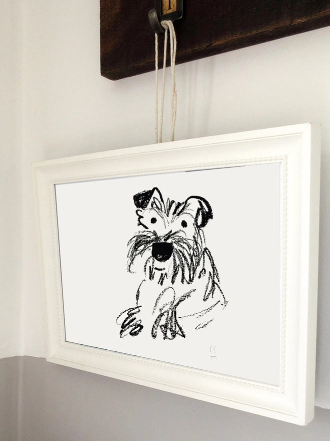 black and white line drawing of dog in white frame hanging on wall