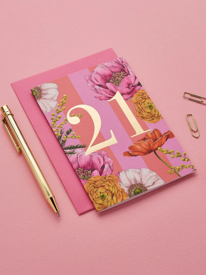 floral age milestone card. a pink floral 21st birthday card photographed against a pink background.
