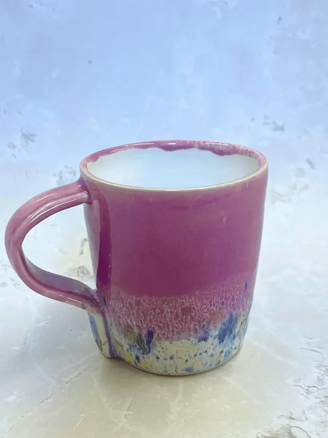Shoreline Standard Mug, a colourful mug placed on a stone surface. 
