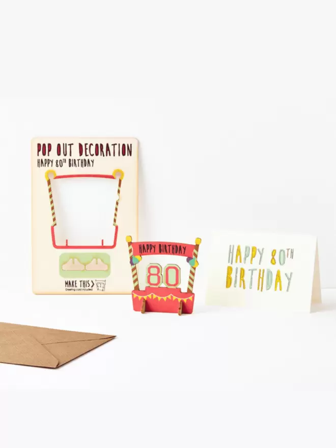 Eightieth birthday decoration and eightieth birthday card and brown kraft envelope on a white background