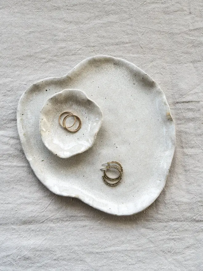 Lily Pad Jewellery Dish In Sea Salt Glaze, dishes stacked on top of each other with rings in them, on a table cloth. 