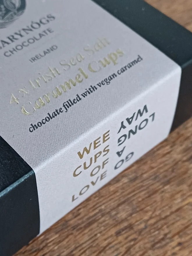 Vegan Irish Sea Salt Chocolate Caramel Cups 60% (Box Of 4), a box of chocolate cups sitting on a wooden surface. 