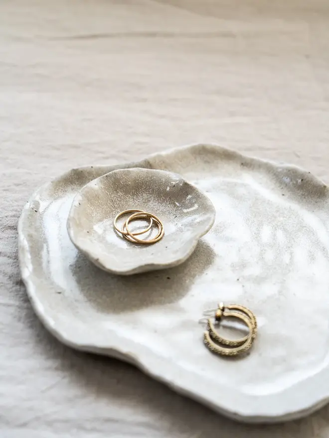 Lily Pad Jewellery Dish In Sea Salt Glaze, dishes stacked on top of each other with rings in them, on a table cloth. 